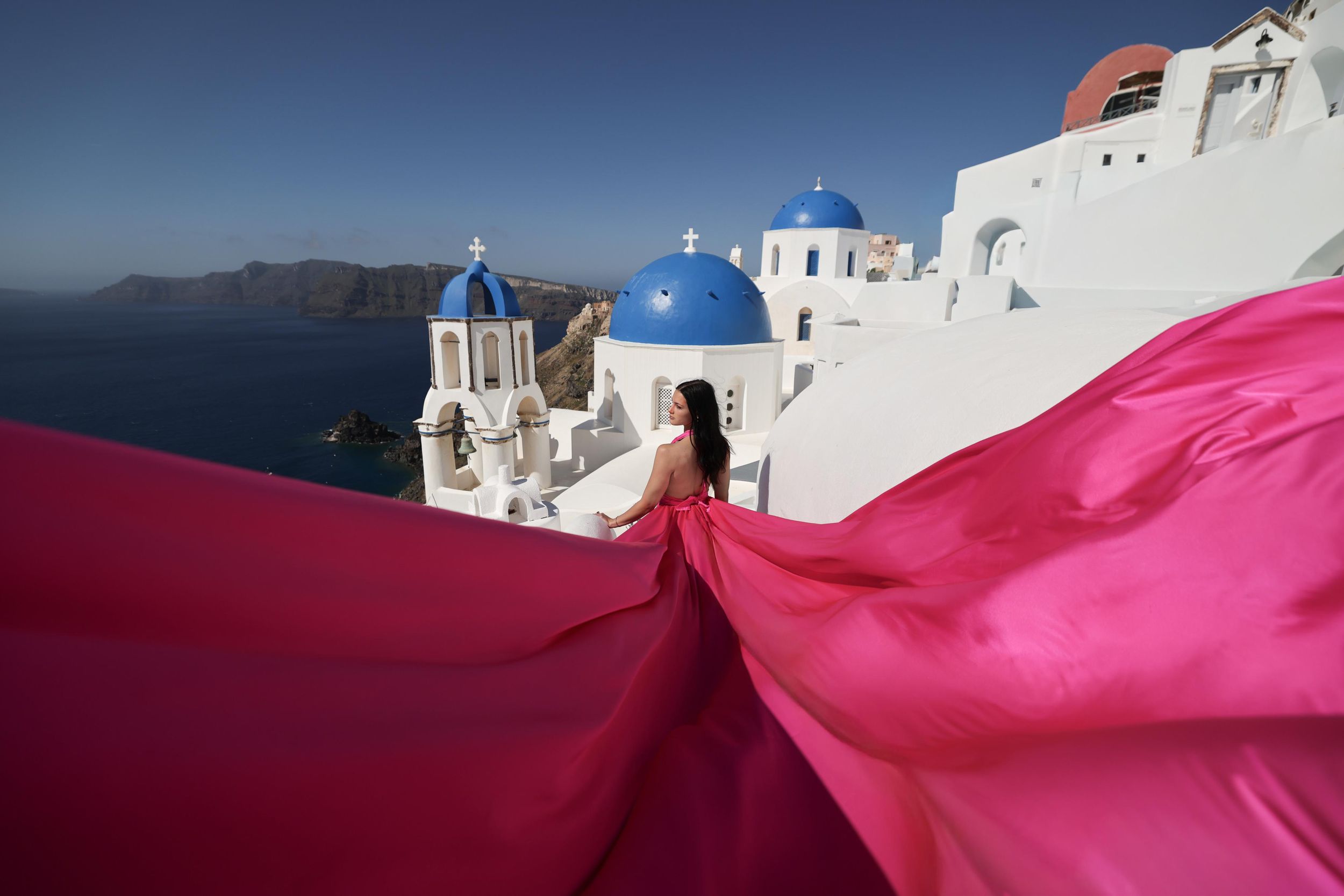 Fotoshooting mit fliegendem Kleid auf Santorin in Oia oder Imerovigli