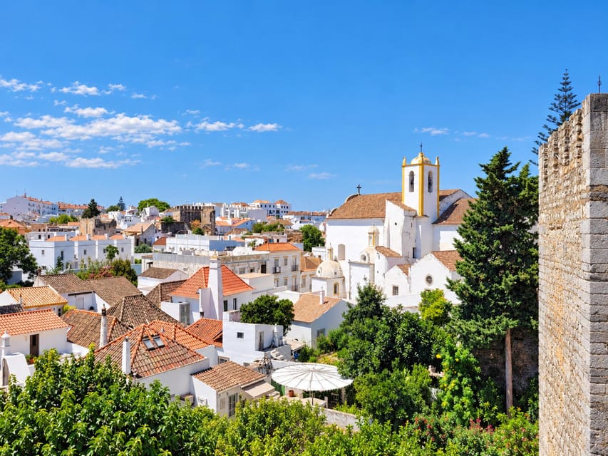 Whitewashed houses and a church tower in Tavira's old town seen from the castle wall