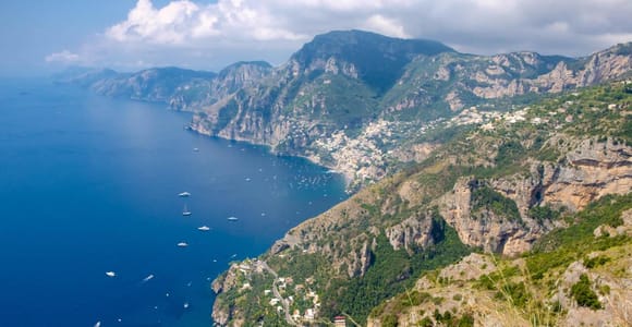 A narrow mountain path crossing a green slope high above the Amalfi Coast