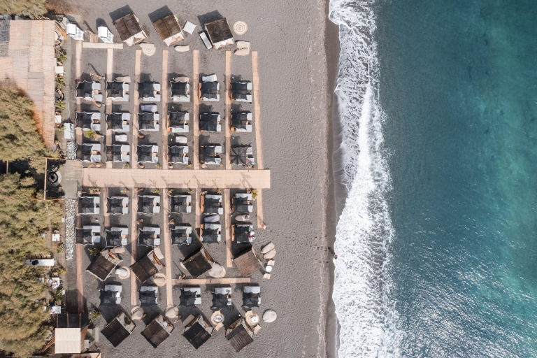Plaża Perivol: leżakowanie w restauracji FortyOne BarLeżaki w drugim rzędzie z ręcznikami, butelką wina, owocami i sushi
