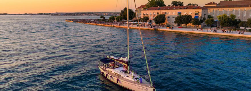Croisière élégante au coucher du soleil sous les voiles, grand yacht, tout confort