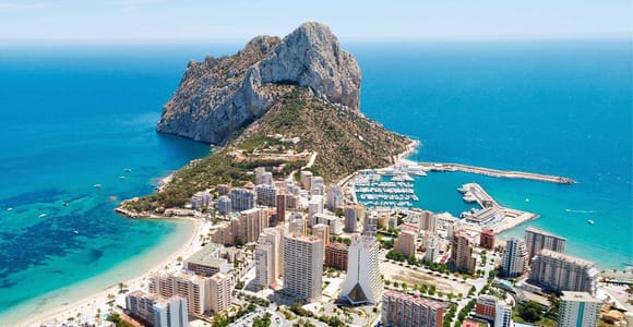 Aerial view of the Peñón de Ifach rock above Calpe’s apartment blocks, sandy beach and marina